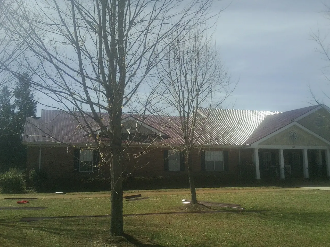 Red metal roof on a brick building seen from the front lawn in Ocean Isle Beach