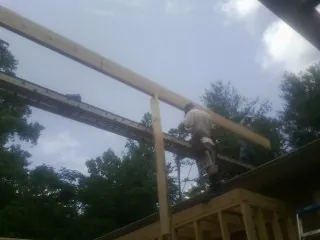 Carpenter setting a ridge beam over a new addition frame — Ice Dam Removal by Roofing Brothers in Ocean Isle Beach