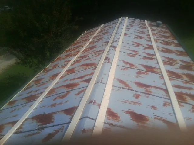 Rusted metal roof panels with new wood purlins before replacement — Storm Damage Roof Repair in Ocean Isle Beach by Roofing Brothers