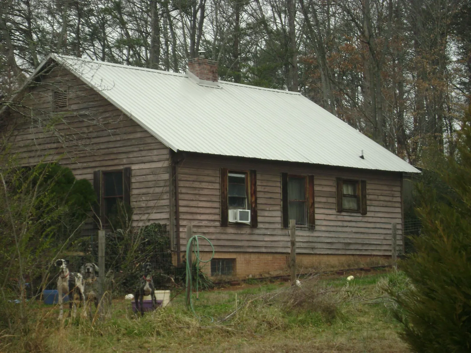 White metal roof on an old wood sided farmhouse, from a Metal Roof Installation job in Ocean Isle Beach